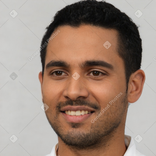 Joyful latino young-adult male with short  black hair and brown eyes