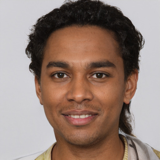 Joyful black young-adult male with short  black hair and brown eyes