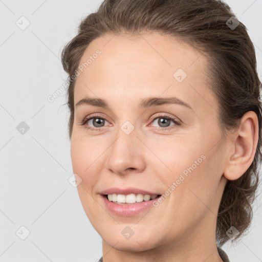 Joyful white young-adult female with medium  brown hair and grey eyes