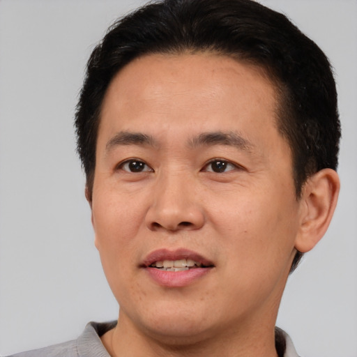 Joyful asian young-adult male with short  brown hair and brown eyes