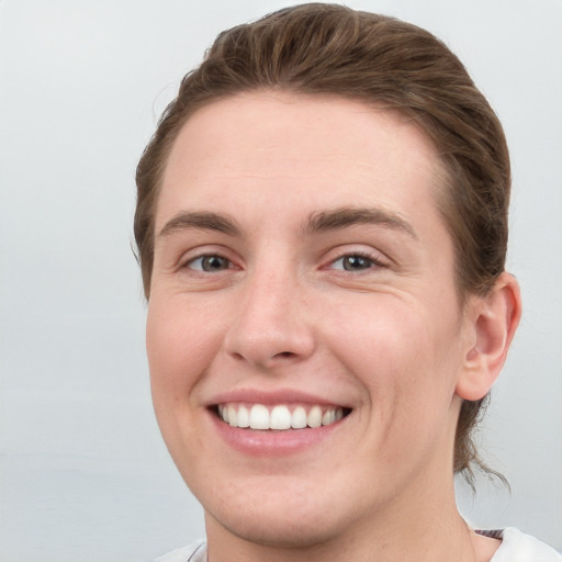 Joyful white young-adult female with short  brown hair and grey eyes