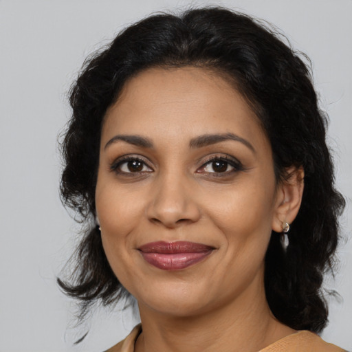 Joyful latino adult female with medium  brown hair and brown eyes