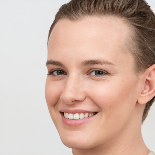 Joyful white young-adult female with short  brown hair and grey eyes