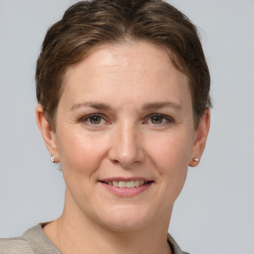 Joyful white young-adult female with short  brown hair and grey eyes