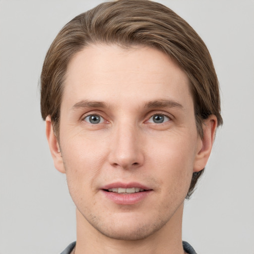 Joyful white young-adult male with short  brown hair and grey eyes