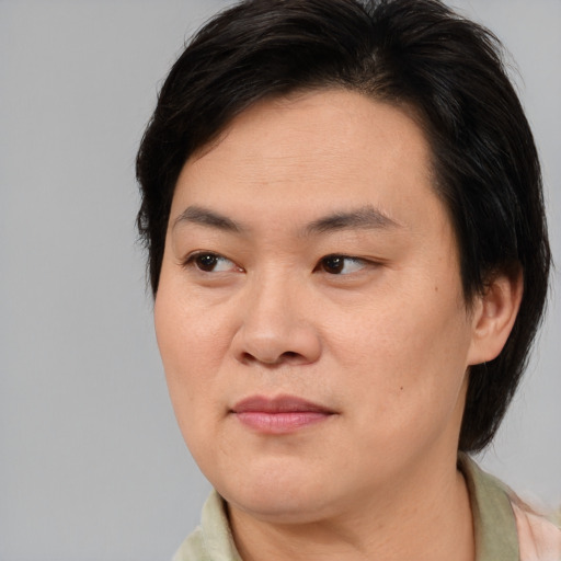 Joyful asian adult female with medium  brown hair and brown eyes