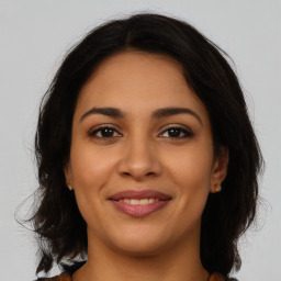 Joyful latino young-adult female with medium  brown hair and brown eyes