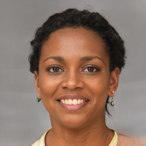 Joyful black young-adult female with short  brown hair and brown eyes