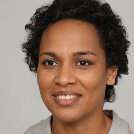 Joyful black young-adult female with medium  brown hair and brown eyes