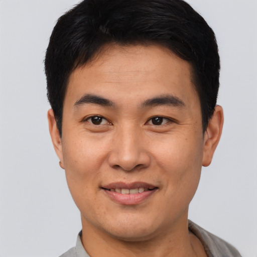 Joyful asian young-adult male with short  black hair and brown eyes
