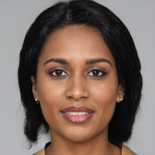 Joyful black young-adult female with medium  black hair and brown eyes