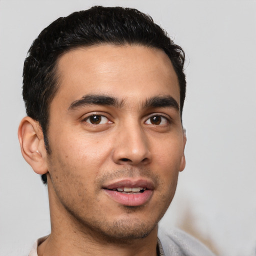Joyful white young-adult male with short  black hair and brown eyes