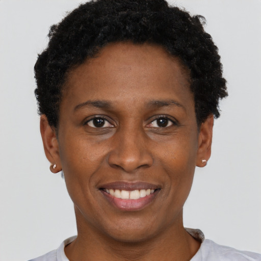 Joyful black young-adult female with short  black hair and brown eyes