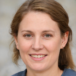 Joyful white adult female with medium  brown hair and blue eyes