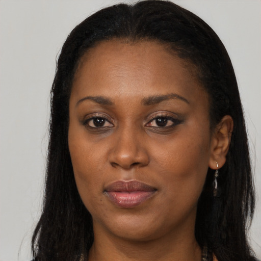 Joyful black young-adult female with long  brown hair and brown eyes