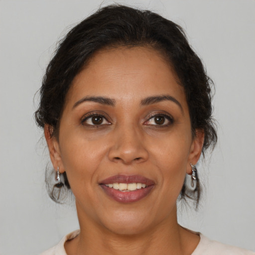 Joyful latino adult female with medium  brown hair and brown eyes