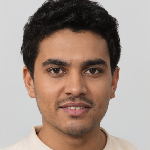 Joyful latino young-adult male with short  brown hair and brown eyes
