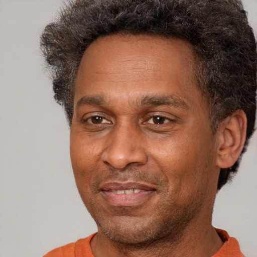 Joyful black adult male with short  brown hair and brown eyes