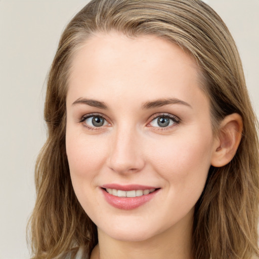 Joyful white young-adult female with long  brown hair and blue eyes