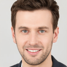 Joyful white young-adult male with short  brown hair and grey eyes