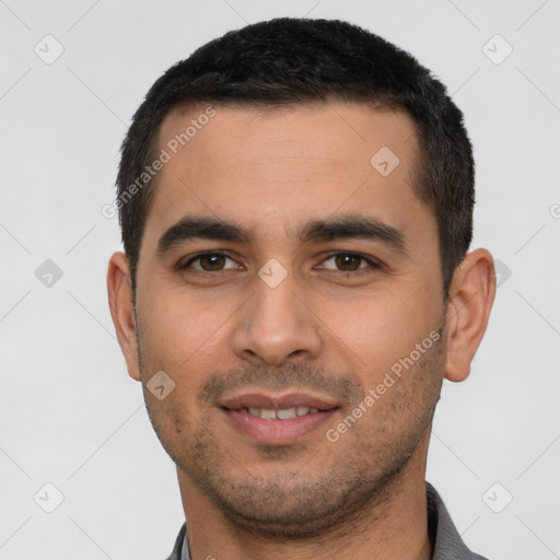 Joyful latino young-adult male with short  black hair and brown eyes