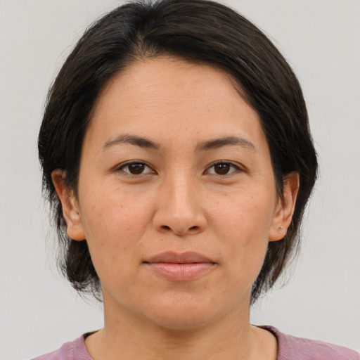 Joyful asian adult female with medium  brown hair and brown eyes