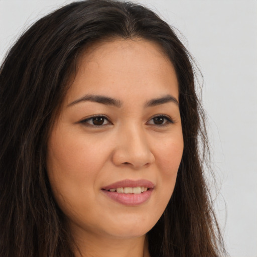 Joyful latino young-adult female with long  brown hair and brown eyes