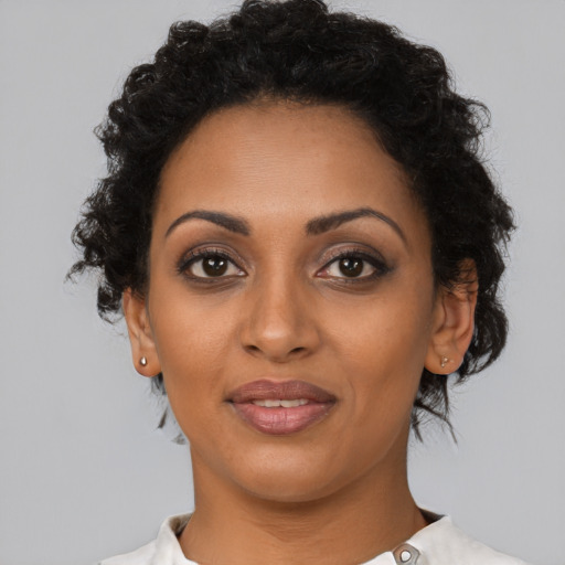Joyful black young-adult female with short  brown hair and brown eyes