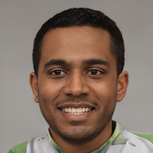 Joyful black young-adult male with short  black hair and brown eyes