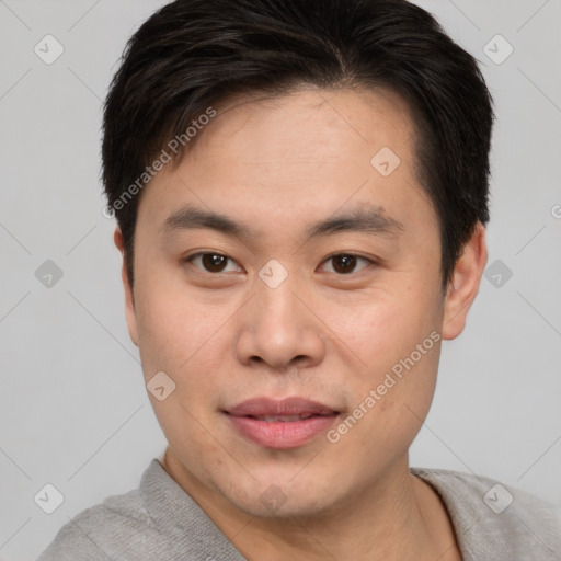 Joyful asian young-adult male with short  brown hair and brown eyes