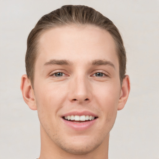 Joyful white young-adult male with short  brown hair and grey eyes