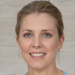 Joyful white adult female with medium  brown hair and grey eyes