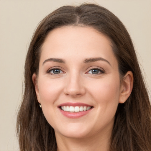 Joyful white young-adult female with long  brown hair and grey eyes