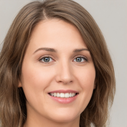 Joyful white young-adult female with medium  brown hair and green eyes