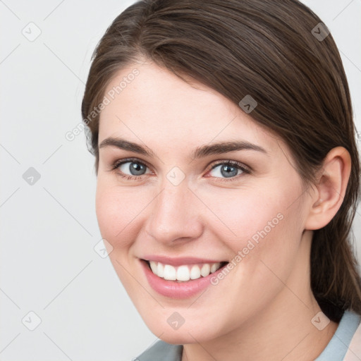 Joyful white young-adult female with medium  brown hair and grey eyes