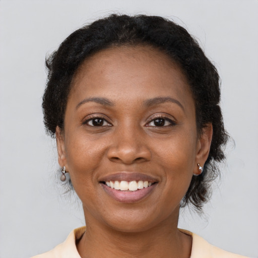 Joyful black young-adult female with short  brown hair and brown eyes