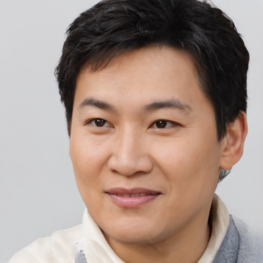 Joyful asian young-adult male with short  brown hair and brown eyes