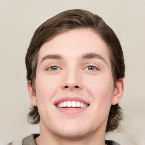 Joyful white young-adult male with medium  brown hair and brown eyes