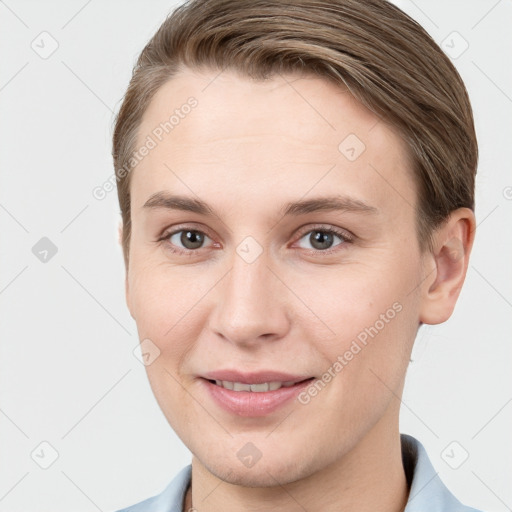 Joyful white young-adult female with short  brown hair and grey eyes