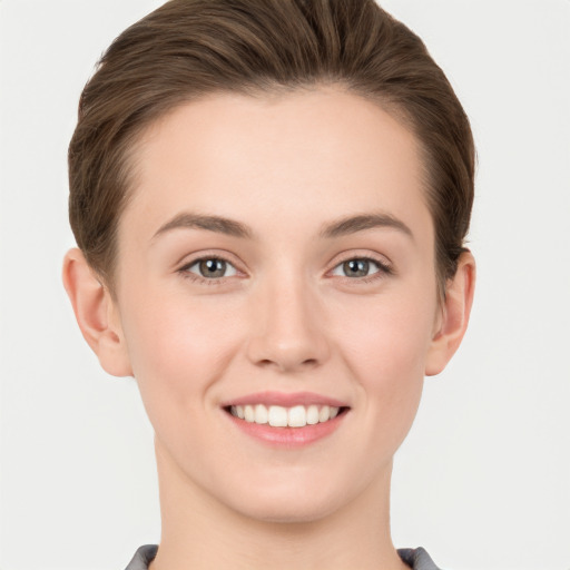 Joyful white young-adult female with short  brown hair and grey eyes