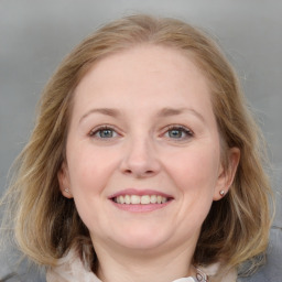 Joyful white young-adult female with medium  brown hair and blue eyes