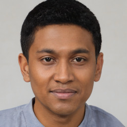 Joyful latino young-adult male with short  black hair and brown eyes