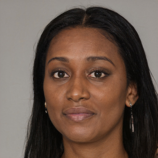 Joyful black adult female with long  black hair and brown eyes