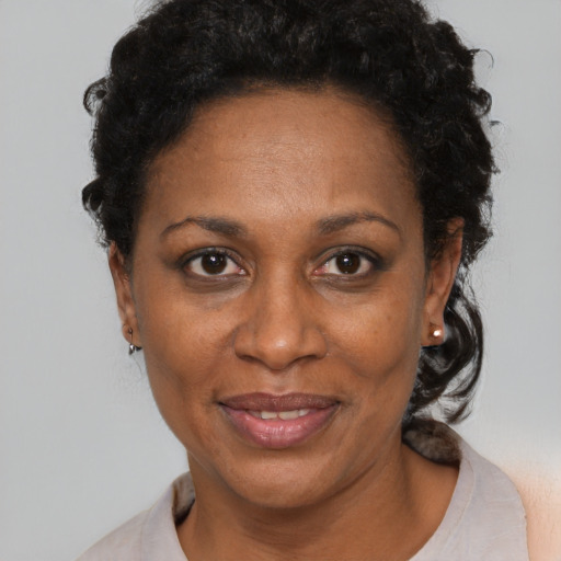 Joyful black adult female with short  black hair and brown eyes