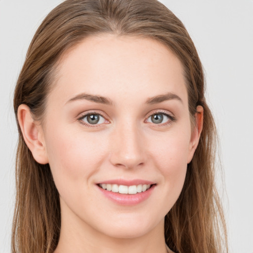 Joyful white young-adult female with long  brown hair and blue eyes