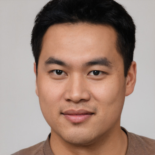Joyful asian young-adult male with short  black hair and brown eyes