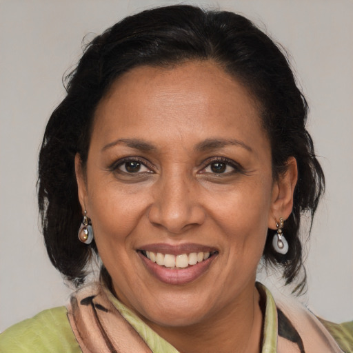 Joyful latino adult female with medium  brown hair and brown eyes