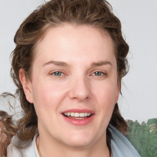 Joyful white young-adult female with medium  brown hair and blue eyes