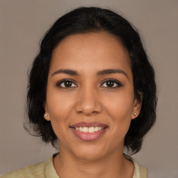 Joyful latino young-adult female with long  brown hair and brown eyes