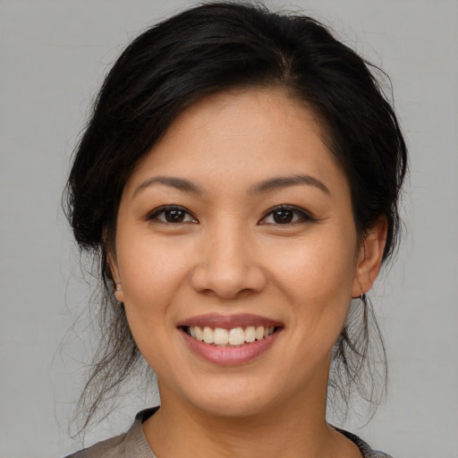 Joyful asian young-adult female with medium  brown hair and brown eyes